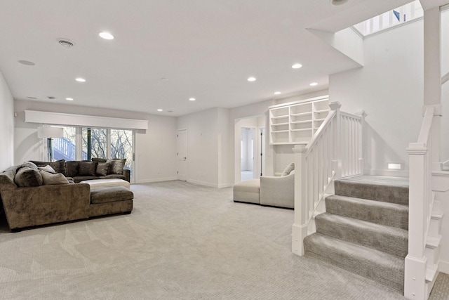 living room featuring recessed lighting, light carpet, baseboards, and stairs