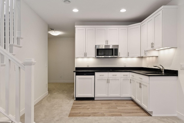 kitchen with stainless steel microwave, white cabinetry, and recessed lighting