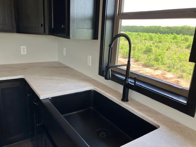 interior details with light countertops, dark cabinets, and a sink