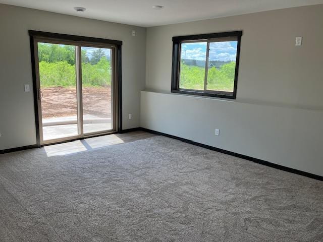 unfurnished room with baseboards and carpet