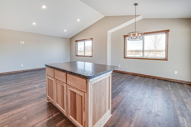 kitchen with dark countertops, dark wood-style floors, an inviting chandelier, and vaulted ceiling