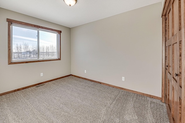 carpeted empty room with baseboards and visible vents