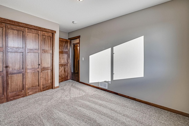 unfurnished bedroom with visible vents, baseboards, and carpet floors