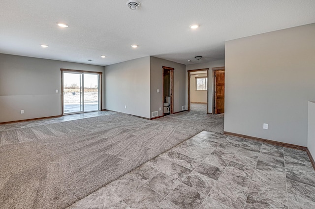 empty room featuring carpet, visible vents, baseboards, recessed lighting, and a textured ceiling