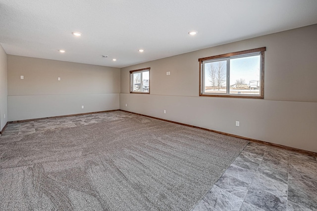 empty room featuring recessed lighting and baseboards