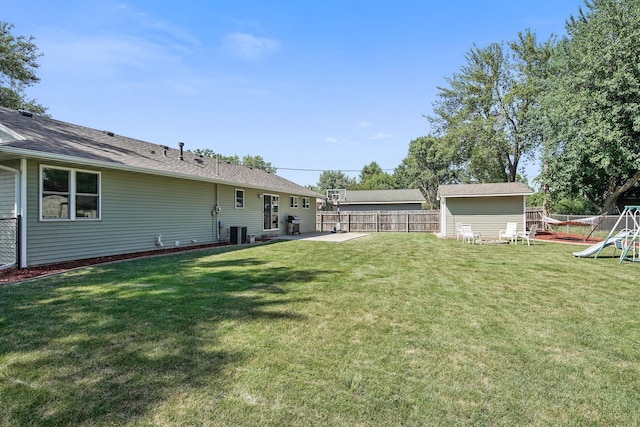 view of yard with a patio, a playground, fence, and central AC