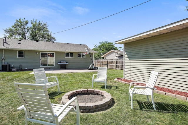 view of yard featuring a patio area, central air condition unit, fence, and an outdoor fire pit