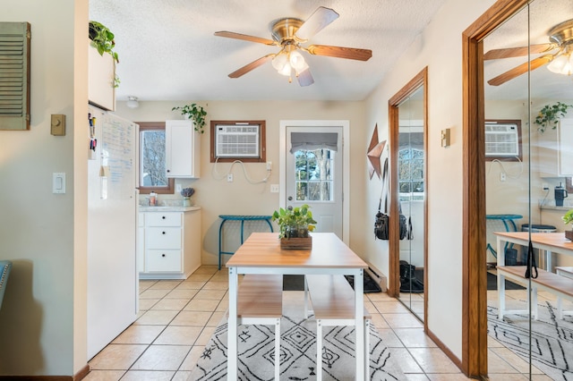 dining room featuring light tile patterned floors, a textured ceiling, a ceiling fan, and an AC wall unit