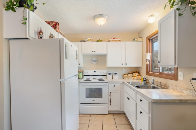 kitchen with light countertops, white appliances, a sink, and white cabinetry