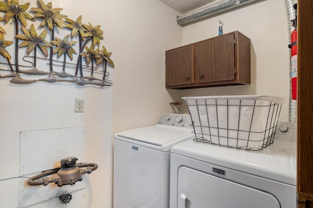 clothes washing area featuring cabinet space and washing machine and clothes dryer