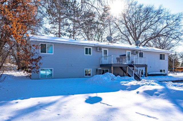 snow covered house with stairs and a deck