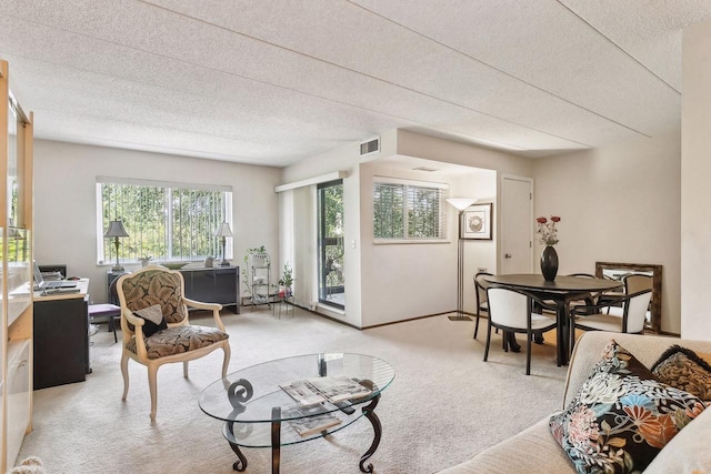 living area featuring light carpet and visible vents