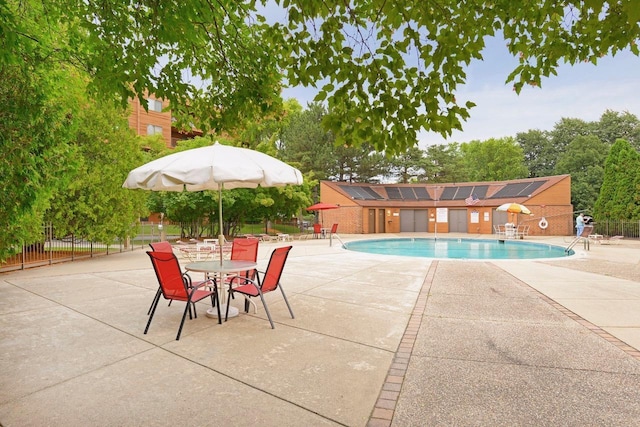 community pool with a patio and fence