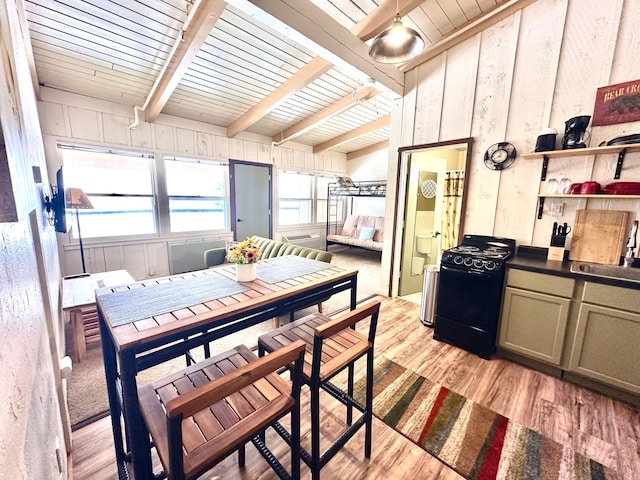 dining room with lofted ceiling with beams, wooden ceiling, light wood-style flooring, and wooden walls