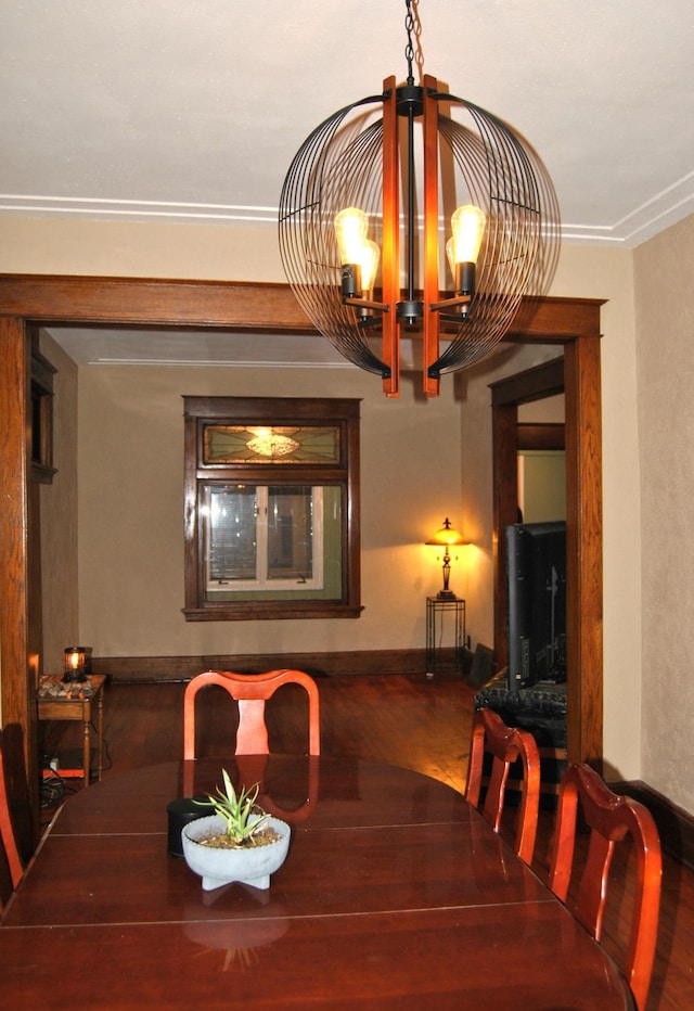 dining space featuring a chandelier, wood finished floors, and baseboards