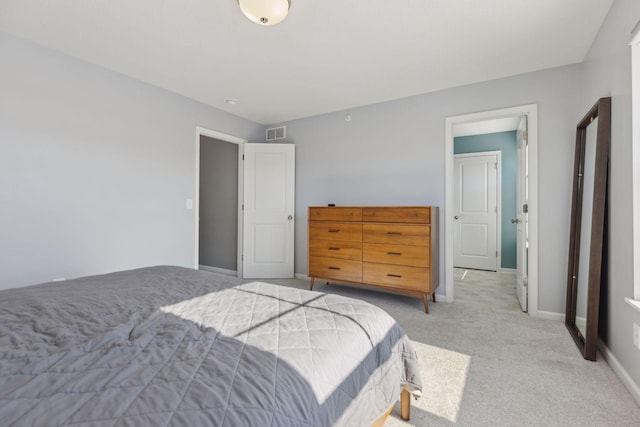 bedroom with visible vents, light carpet, and baseboards