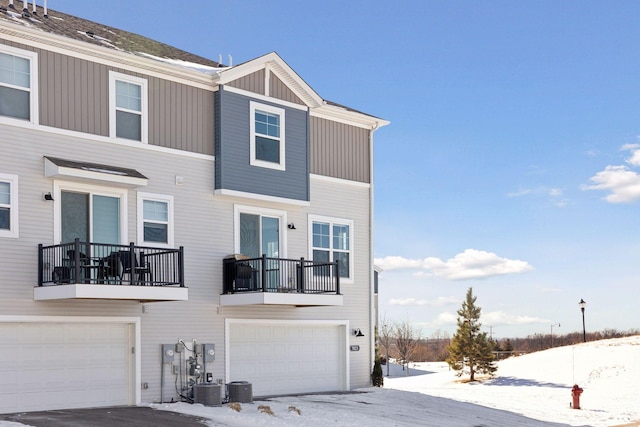 townhome / multi-family property featuring central AC, a balcony, and an attached garage