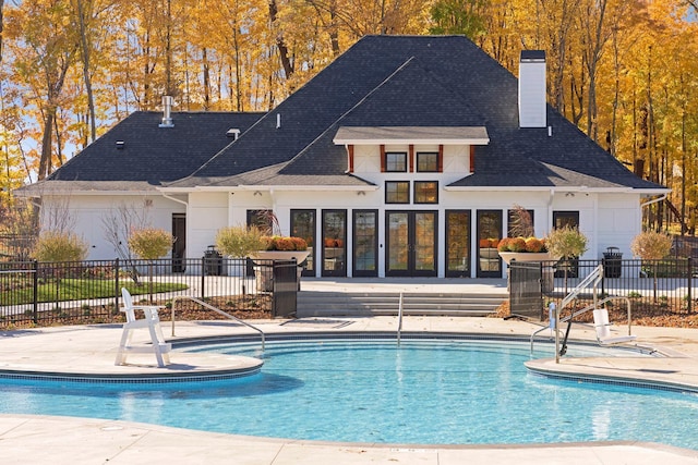 community pool with a patio area and fence