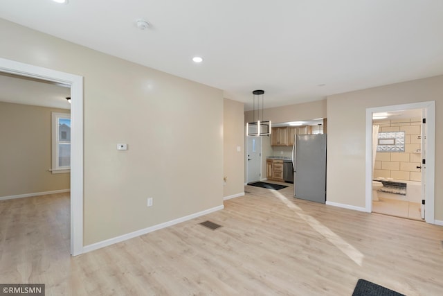 unfurnished living room with baseboards and light wood finished floors