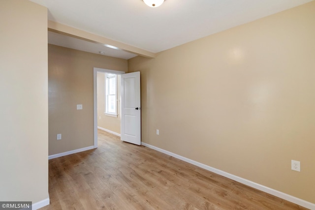 unfurnished room with light wood-style floors and baseboards