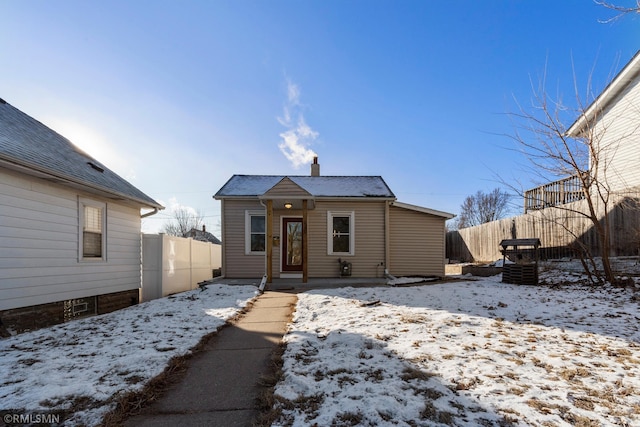 bungalow with a chimney and fence