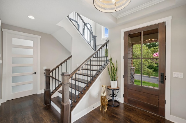 foyer entrance with recessed lighting, crown molding, baseboards, and wood finished floors