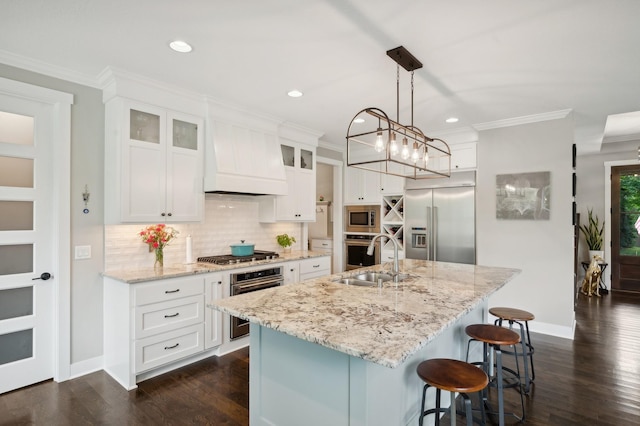 kitchen featuring premium range hood, crown molding, backsplash, and built in appliances