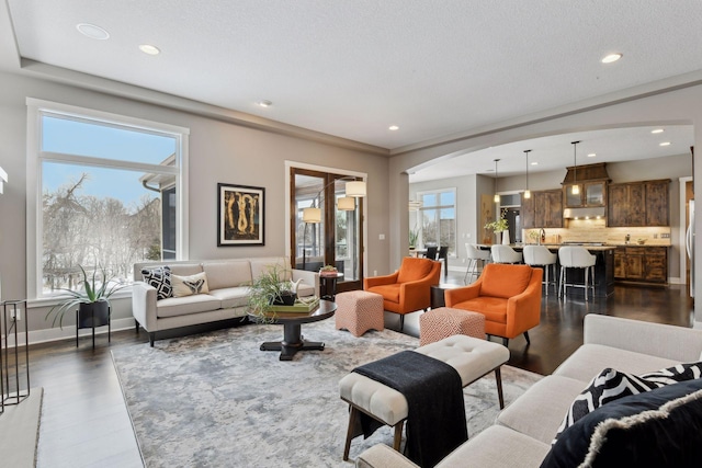 living room featuring recessed lighting, dark wood finished floors, a textured ceiling, and baseboards