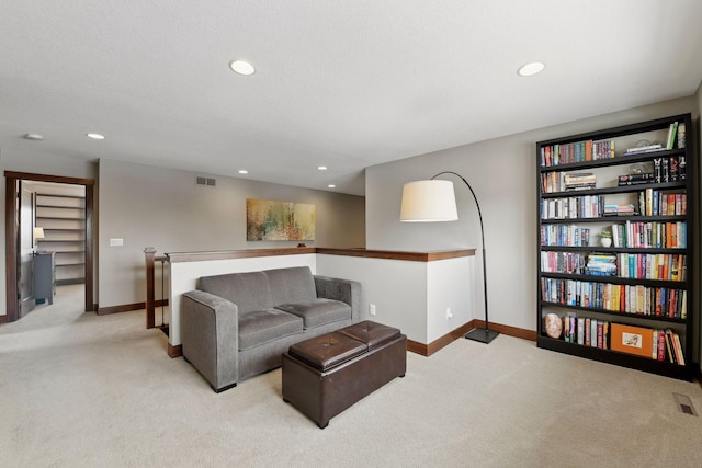 living area featuring recessed lighting, visible vents, baseboards, and light colored carpet