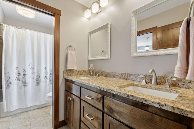 full bath featuring double vanity, toilet, a sink, and tile patterned floors