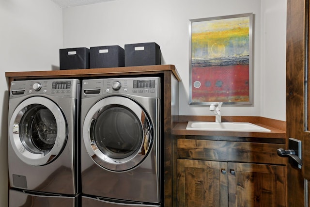 washroom with washing machine and dryer, laundry area, and a sink