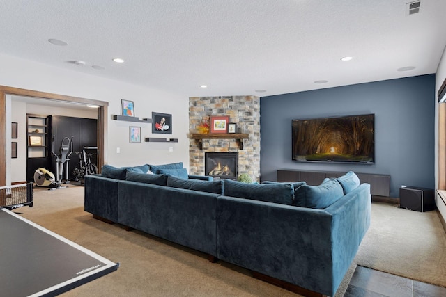 living room with light carpet, a fireplace, visible vents, and a textured ceiling