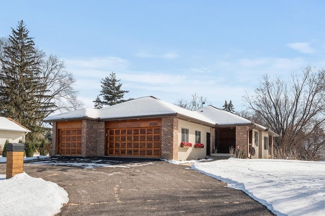 view of front of house featuring a garage, brick siding, and aphalt driveway