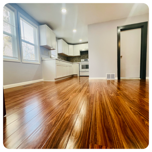 kitchen featuring visible vents, white cabinets, decorative backsplash, light wood finished floors, and white electric range oven