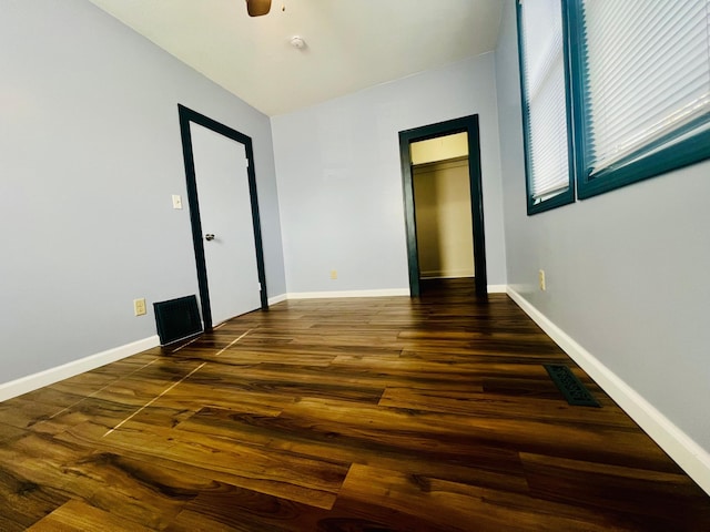 unfurnished room featuring visible vents, ceiling fan, baseboards, and wood finished floors