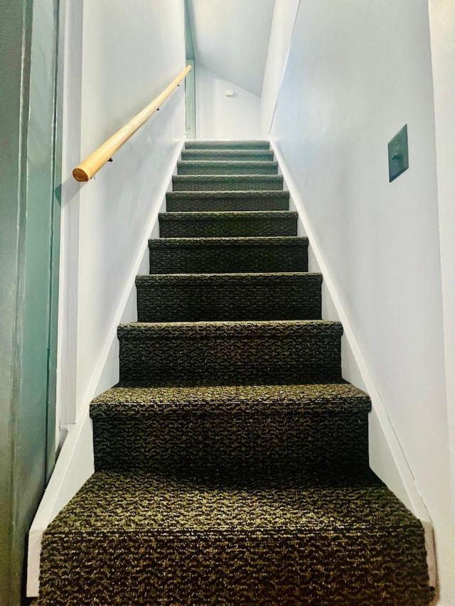 staircase featuring lofted ceiling