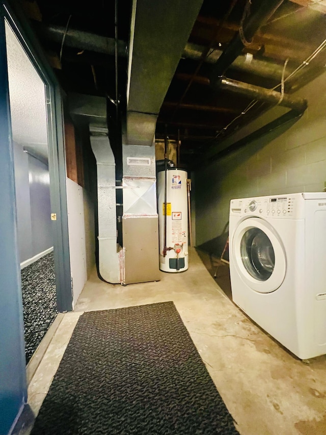 laundry area featuring heating unit, laundry area, water heater, and washer / clothes dryer