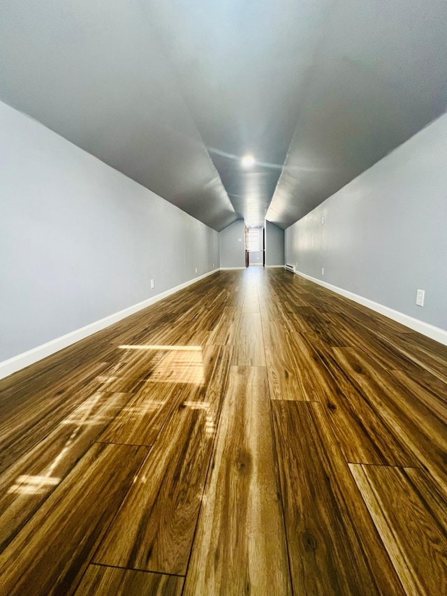 bonus room featuring lofted ceiling, dark wood finished floors, and baseboards