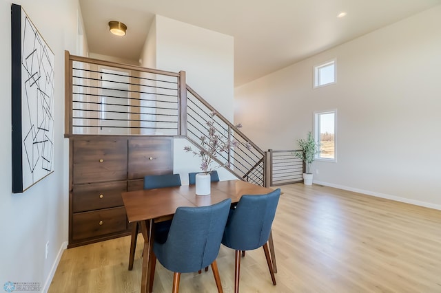 dining room featuring light wood-style floors, stairs, baseboards, and recessed lighting