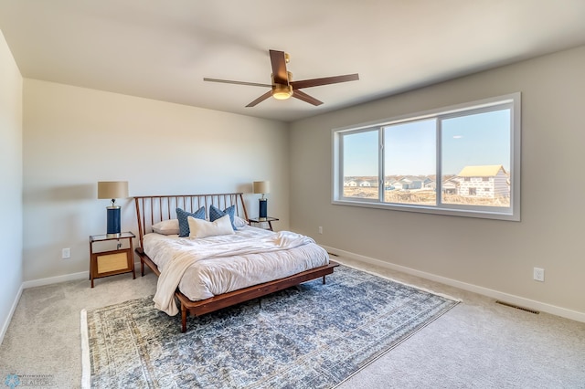 carpeted bedroom featuring visible vents, baseboards, and a ceiling fan