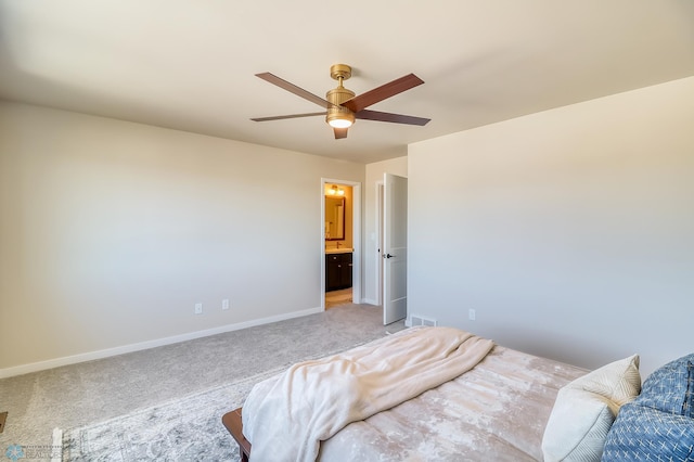 bedroom with visible vents, a ceiling fan, light carpet, ensuite bath, and baseboards