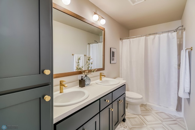 bathroom with double vanity, visible vents, toilet, and a sink