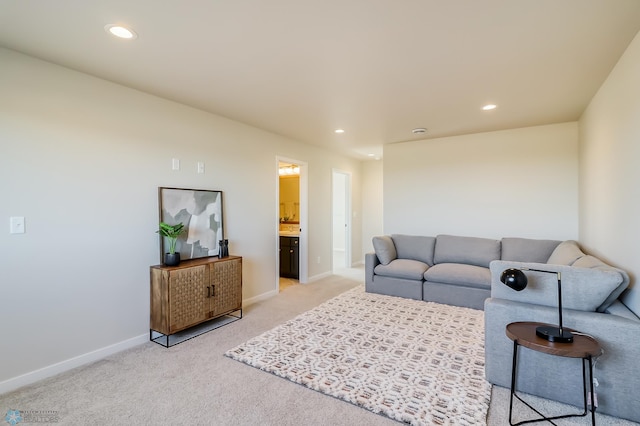 living room with recessed lighting, light colored carpet, and baseboards