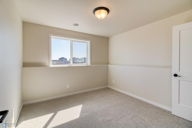 carpeted empty room featuring baseboards