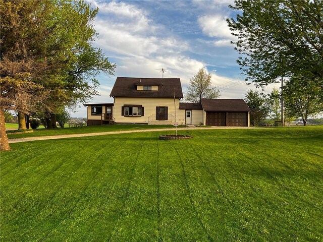 rear view of property with a yard and a detached garage