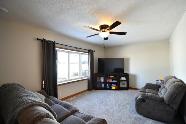 carpeted living room with a textured ceiling, baseboards, ceiling fan, and visible vents
