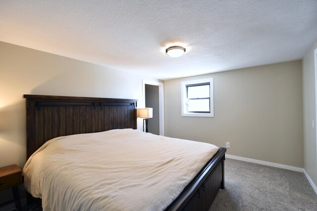 bedroom with dark carpet and baseboards