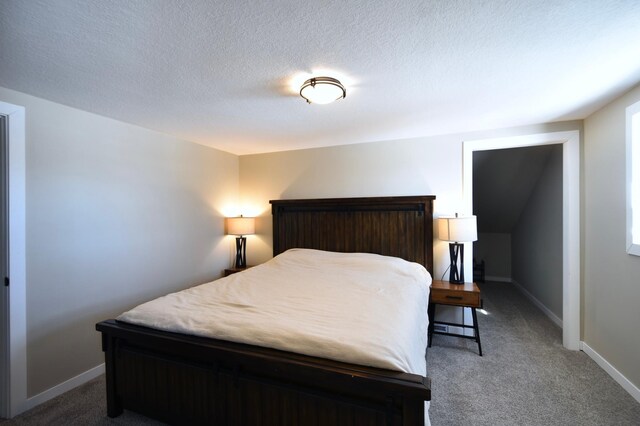 carpeted bedroom featuring baseboards and a textured ceiling