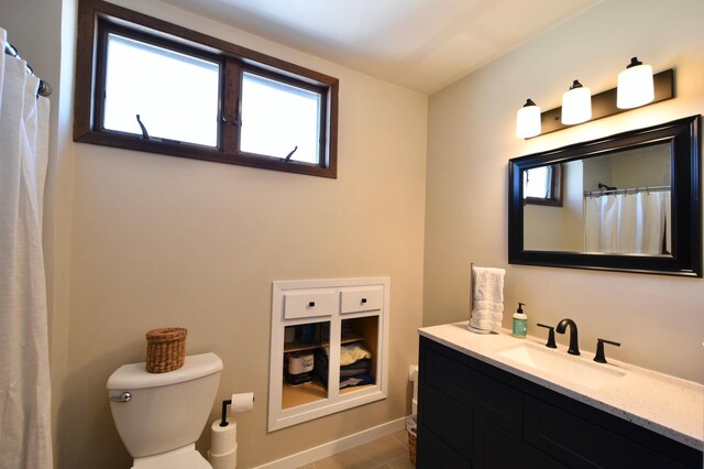 full bathroom with toilet, vanity, and baseboards