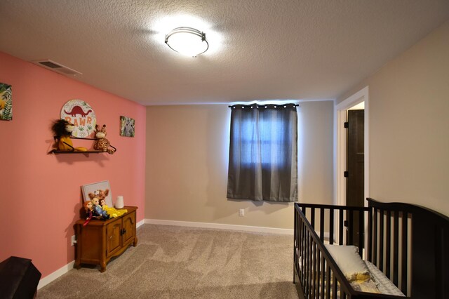 bedroom featuring light carpet, a textured ceiling, visible vents, and baseboards